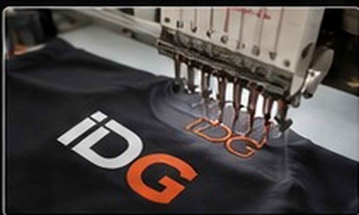 Máquina realizando bordado sobre prenda corporativa
